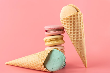 Macaroons stacked on a pink background. Delicious dessert of French cuisine, creatively decorated on...