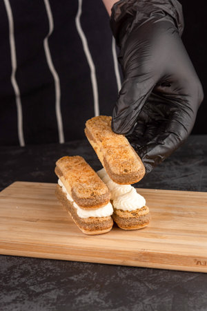 Making dessert tiramisu cake on a dark background in a coffee shopの写真素材