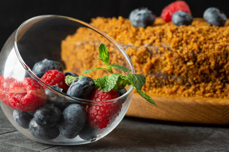 carrot cake decorated with blueberries and raspberries on a dark background. selective focusの写真素材