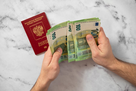 Passport of the Russian Federation and euro banknotes. Concepts of travel, economic sanctions, money transfers and inflation for Russian citizensのeditorial素材