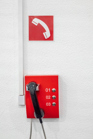 The red emergency telephone in the office building. Telephone system for calling firefighters
