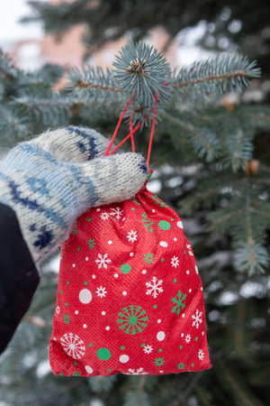 red Christmas gift is hanging on pine tree outdoors.の写真素材