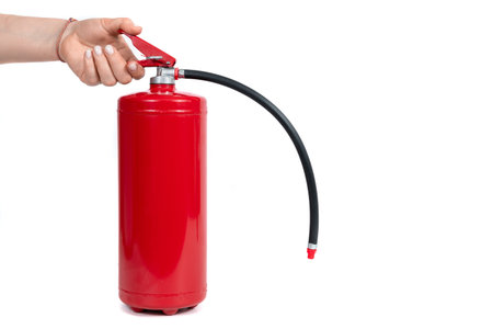 A red fire extinguisher with black hose on white backgroundの写真素材