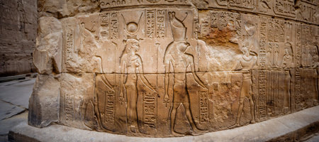 Ancient Egyptian hieroglyphs and relief drawings on one of the walls of the Edfu complex. Temple of...