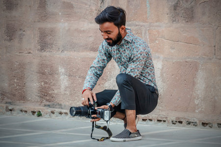 Jaisalmer, India - March 16, 2020: A photographer with his camera outdoors is looking for a beautiful camera angle.のeditorial素材