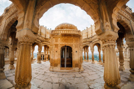 The royal cenotaphs of historic rulers, also known as Jaisalmer Chhatris, at Bada Bagh in Jaisalmer made of yellow sandstone at sunsetの写真素材
