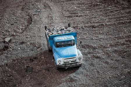 Blue truck transporting granite boulders in the back in an industrial quarryの写真素材