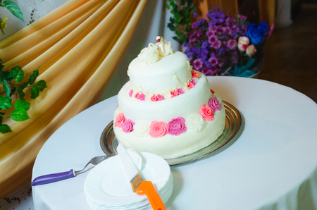 white multi level wedding cake with pink flower decorationsの写真素材