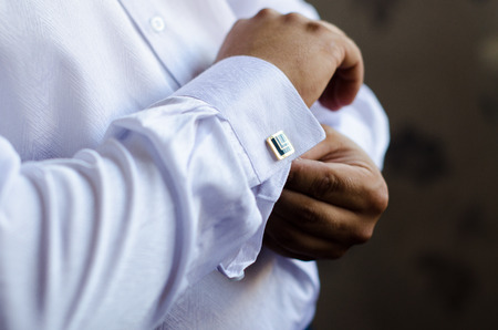 The handsome groom wears a wedding cufflinks. Wedding preparationの写真素材