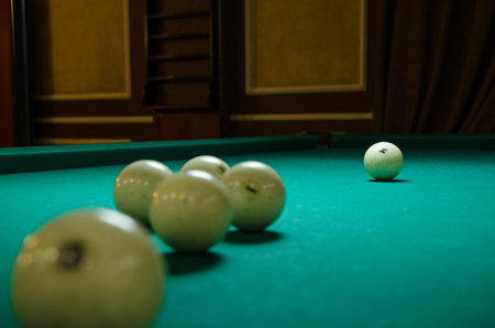 Russian billiards white balls, yellow cue ball on a large table with green cloth
