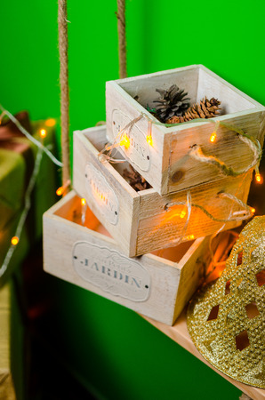 Christmas. Cones in the wooden box on the green wall backgroundの写真素材