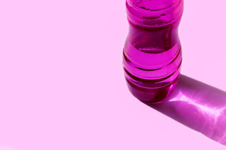 Pink water bottle. Girl's fitness accessory for sport. Monochrome banner, poster with copy space. Reusable neon bottle. Healthy lifestyle concept. Glamor plastic drinking containerの写真素材
