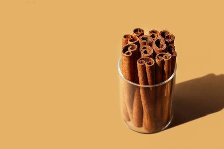 Cassia sticks in clear glass on beige background. Horizontal template for banner, poster, copy...