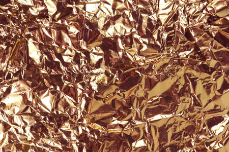 Copper foil texture. Crumpled metal background. Horizontal photo for festive design. Template for banner, poster with copy space for holiday and congratulationsの写真素材