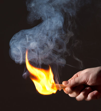 Burning match in hand. Smokeの写真素材