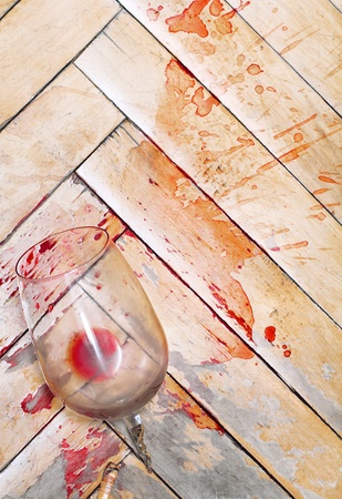 Broken wine glass on the old parquet. Splashes of wine similar to bloodの写真素材