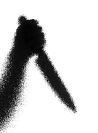 Knife in a hand. Silhouette. Photographed through the textured glass.の写真素材
