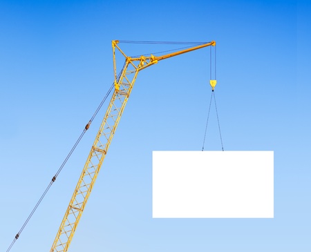 hoisting crane with empty board against the blue skyの写真素材