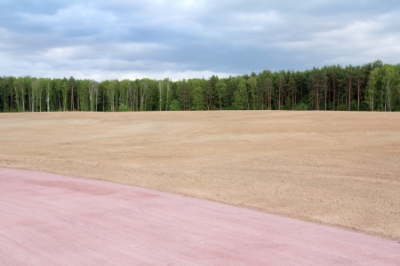 Abstract landscape with bare field and roadの写真素材