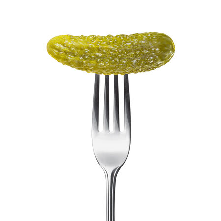 marinated pickled cucumber on a fork isolated on a white backgroundの写真素材