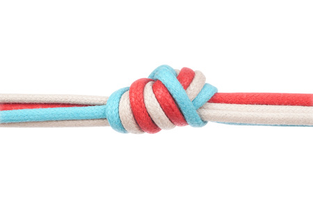 Ropes or shoelaces tied in a knot on a white backgroundの写真素材