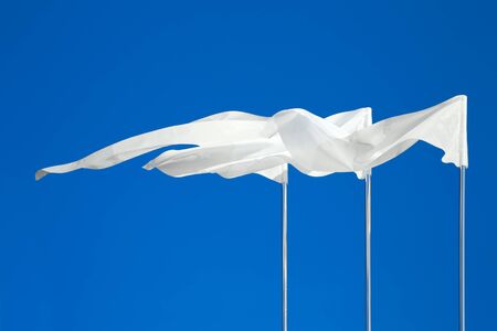 White flags against the blue skyの写真素材