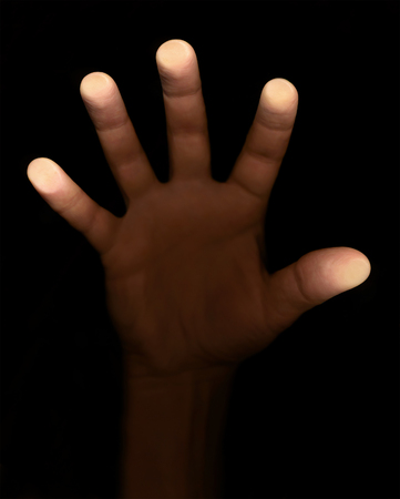 fingers touch the glass on a black backgroundの写真素材