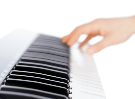 Hand and piano keyboard on white backgroundの写真素材
