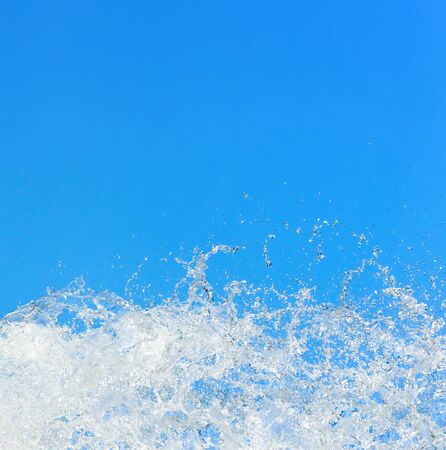 Water splashing on the background of blue sky                            の写真素材