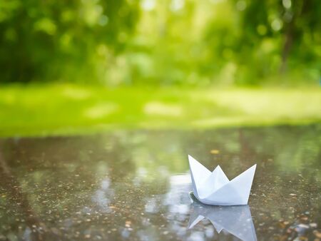 Paper boat floating in a puddleの写真素材