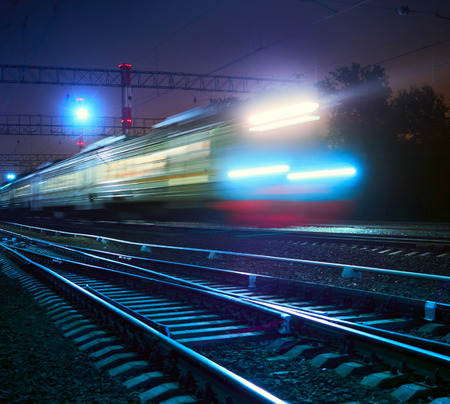 train rushes on rails at nightの写真素材