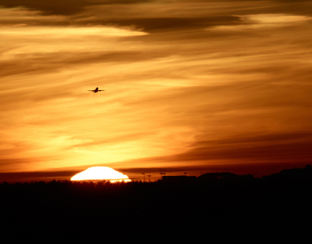 airplane takes off against the sun and skyの写真素材