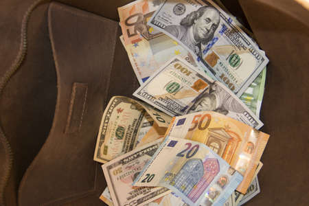 Money lies in a heap on the table scattered. Dollars and euro money lie on the table scattered chaotically.の写真素材