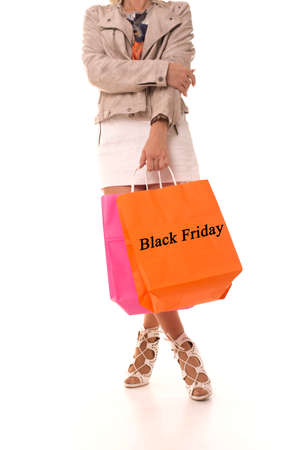 The girl stands on a white background with the inscription on the package Black Friday. Girl with a package in her hands after the sale.の写真素材