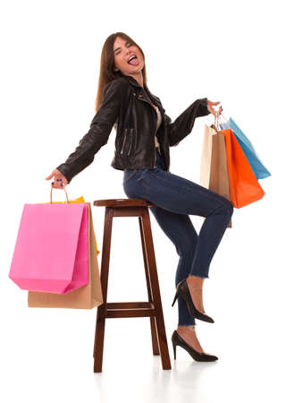 Girl with purchases sits and shows her tongue.の写真素材