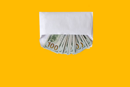 Money in an envelope lies on a yellow background.の写真素材