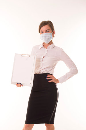 Girl stands in a medical mask and holds a tablet.の写真素材