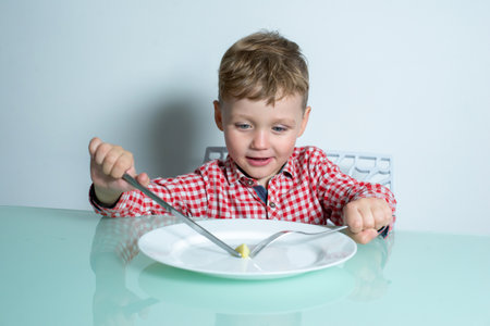 Child sits at the table and eats food.の写真素材