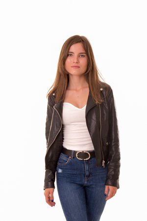 Sad girl standing in leather jacket on white.の写真素材