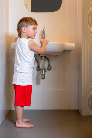 Little boy in pajamas stands in the bathroom.の写真素材