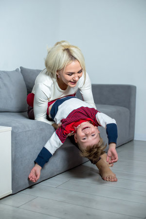 Mom plays with little son at home on the bed.の写真素材