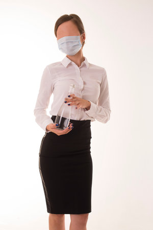 Girl in a medical mask stands with a bottle.の写真素材