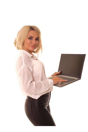 Young girl with a laptop stands and typing on it.の写真素材