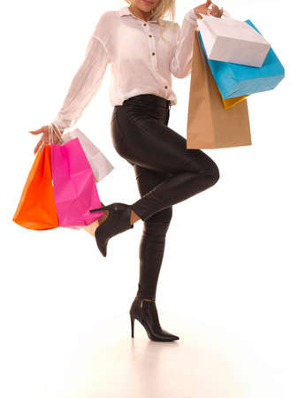 Girl stands on one leg and holds packages.の写真素材