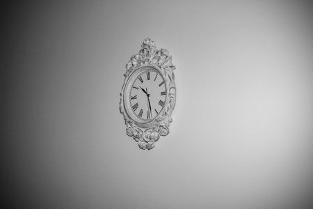 A white clock with black arms on a white wall. black and whiteの写真素材