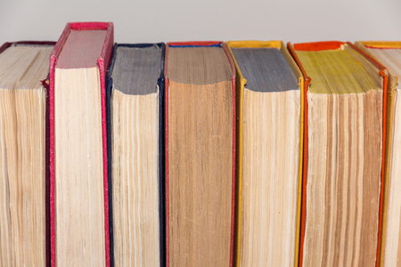 Old books in a multi-colored covers in a rowの写真素材