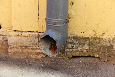 old metal drainpipe on an yellow wallの写真素材