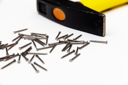 hammer and small construction nails on a white backgroundの写真素材