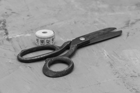old black big scissors on a background of gray plaster. black and white photoの写真素材