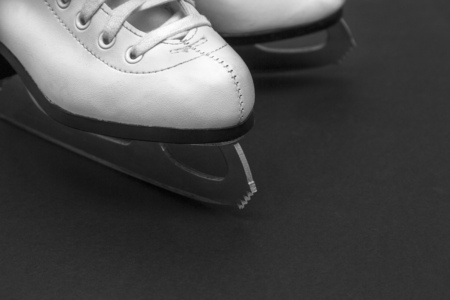 white leather children's figure skates on a dark backgroundの写真素材